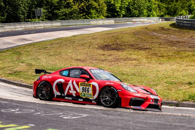 Ein roter Porsche 911 GT3 R Evo fährt eine Kurve auf der Rennstrecke am Nürburgring. Rheinland-Pfalz Deutschland