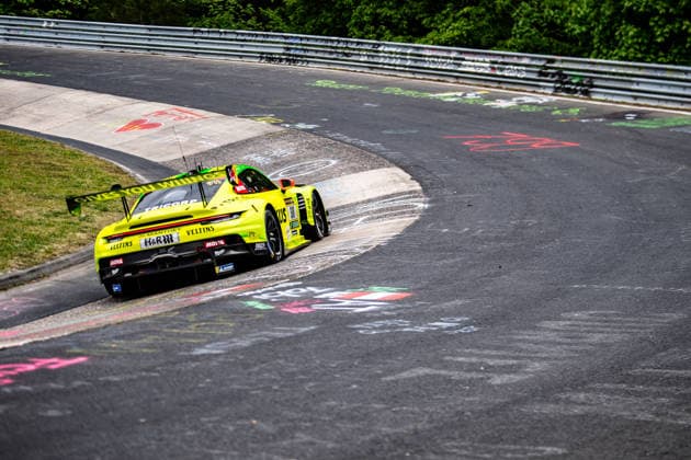 Manthey ( 911) SP 9. Ein gelber Porsche 911 GT3 R mit Sponsorenaufklebern fährt eine Kurve der Nürburgring-Rennstrecke entlang. Rheinland-Pfalz Deutschland