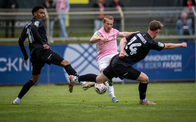 Fussball, Saison 2025 2026, Regionalliga West, 16.05.2026, 34. Spieltag, Herren, 1.FC Bocholt (rosa) vs. RW Oberhausen (schwarz) v.l.: Eric Babacar Gueye (RW Oberhausen), Philipp Hanke (1.FC Bocholt), Simon Ludwig (RW Oberhausen), Bocholt Stadion am Huenting Nordrhein-Westfalen Deutschland