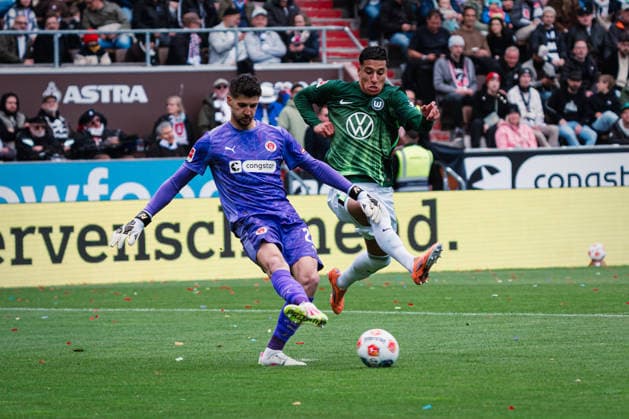 1. Bundesliga: FC St. Pauli vs. VfL Wolfsburg, 16.05.2026 Nikola Vasilj (FC St. Pauli, 22) spielt den Ball vor Adam Daghim (VfL Wolfsburg, 11); Fußball, 1. Bundesliga, 34. Spieltag: FC St. Pauli vs. VfL Wolfsburg am 16.05.2026 im Millerntor-Stadion, Hamburg DFL REGULATIONS PROHIBIT ANY USE OF PHOTOGRAPHS AS IMAGE SEQUENCES AND OR QUASI-VIDEO. Copyright: xBEAUTIFULxSPORTS Tonhäuserx