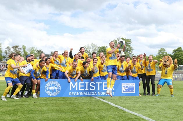 Fußball Regionalliga Nordost: 1. FC Lok Leipzig - 1. FC Magdeburg II; 16.05.2026 Djamal Ziane (13, Lok Leipzig) stemmt den Meister-Pokal in die Luft, während das Lok-Team dahinter jubelt und feiert. Fußball, Regionalliga Nordost, Saison 2025 2026, 34. Spieltag: 1. FC Lok Leipzig vs. 1. FC Magdeburg II am 16.05.2026 im Bruno-Plache-Stadion, Leipzig. Copyright: xBEAUTIFULxSPORTS JanxKaeferx