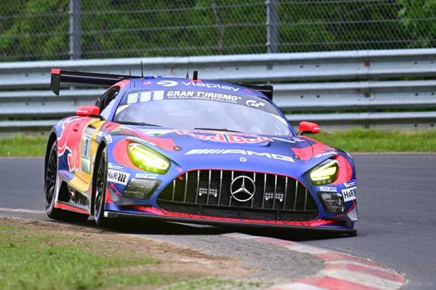 Der Mercedes-AMG GT3 mit der Startnummer 3 des Mercedes-AMG Team Verstappen Racing durchfährt eine Kurve auf dem Nürburgring. Das Fahrzeug Daniel Juncadella & Jules Gounon & Lucas Auer & Max Verstappen (Mercedes-AMG Team Verstappen Racing) präsentiert sich im markanten Red-Bull-Livery in Blau-Rot mit Sponsoren wie Gran Turismo, Viaplay und AMG auf dem Asphalt der Nordschleife beim ADAC RAVENOL 24h Nürburgring 2026. Mercedes-AMG GT3 3 von Verstappen Racing am Nürburgring Copyright: xMichaelxGelhardtx