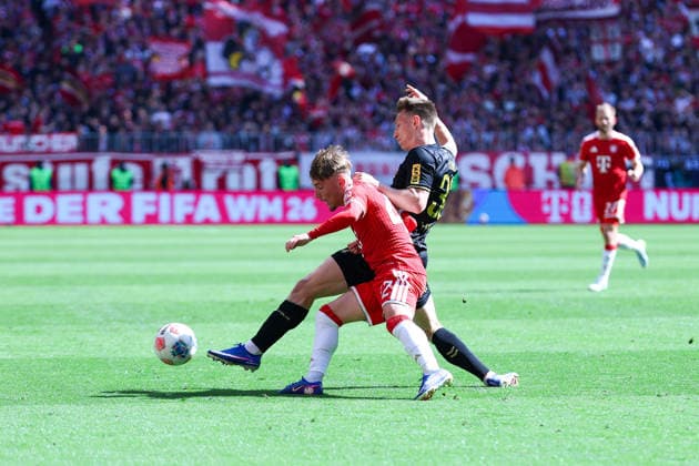GER; 1. FBL, FC Bayern München vs 1. FC Köln 16.05.2026, Allianz Arena, München, GER; 1. FBL, FC Bayern München vs 1. FC Köln, im Bild picture shows Lennart Karl ( FC Bayern München 42 ), links - Kristoffer Lund ( 1. FC Köln 32 ), rechts