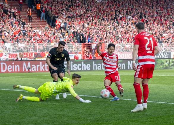 Fußball, Herren, Saison 2025 2026, 1. Bundesliga (34. Spieltag), 1. FC Union Berlin - FC Augsburg, Woo-Yeong Jeong (Wooyeong, 1. FC Union Berlin) erzielt das Tor zum 4:0 gegen Torwart Finn Dahmen (FC Augsburg), 16.05. 2026, Copyright: xMatthiasxKochx