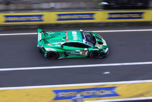 Der grüne Lamborghini mit der Startnummer 130 von Red Bull Team ABT durchfährt die Boxengasse am Nürburgring beim ADAC RAVENOL 24h Nürburgring 2026. Das Fahrzeug Marco Mapelli & Nicholas Yelloly & Nicky Catsburg (Red Bull Team ABT) trägt die Sponsoren Schaeffler, REPXPERT, RAVENOL, H&R und Falken und bewegt sich mit deutlich sichtbarer Bewegungsunschärfe durch die Boxenanlage. Lamborghini 130 von Red Bull Team ABT in der Boxengasse