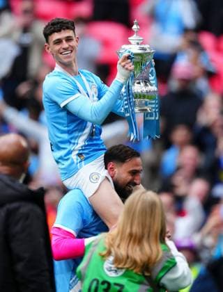 Phil Foden celebrates with the trophy on the shoulders of Manchester City goalkeeper Gianluigi Donnarumma Chelsea v Manchester City, Emirates FA Cup Final, Football, Wembley Stadium, London, UK - 16 May 2026London Wembley Stadium United Kingdom EDITORIAL USE ONLY No use with unauthorised audio, video, data, fixture lists, club league logos or live services. Online in-match use limited to 120 images, no video emulation. No use in betting, games or single club league player publications. Copyright: xJavierxGarcia Shutterstockx 16876844ca