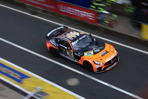 Der Abée Anton & Guilherme de Oliveira & Jörg Viebahn & LLuc Ibanez & Yannik Himmels (PROsport Racing) Mercedes-AMG GT3 von PROsport Racing durchfährt die Boxengasse am Nürburgring. Das auffällige orange-schwarze Fahrzeug mit der Startnummer 176 trägt Sponsoren wie RAVENOL, Dorint und NOVEM CARS. Die Vogelperspektive zeigt das Fahrzeug beim Passieren der weißen Haltelinien in der Boxengasse. Mercedes-AMG GT3 176 von PROsport Racing in der Boxengasse