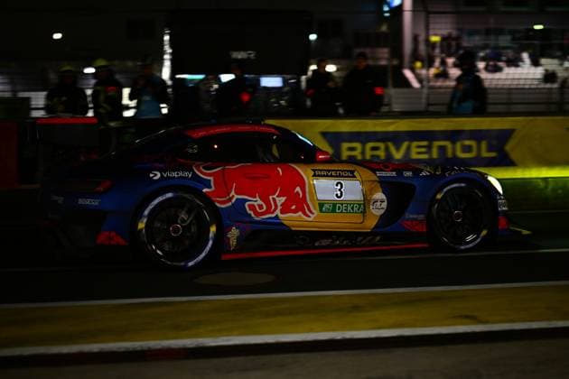 Der Daniel Juncadella & Jules Gounon & Lucas Auer & Max Verstappen (Mercedes-AMG Team Verstappen Racing) von Mercedes-AMG Team Verstappen Racing durchfährt in der Dunkelheit die Boxengasse am Nürburgring. Das Fahrzeug trägt das charakteristische Red-Bull-Design in Blau und Rot mit dem markanten Stier-Logo auf der Flanke. Sponsoren wie RAVENOL, Viaplay und Sparco sind deutlich erkennbar. Im Hintergrund leuchtet das RAVENOL-Banner in sattem Gelb. Mercedes-AMG GT3 3 von Verstappen Racing in der Nacht am Nürburgring Copyright: xMichaelxGelhardtx