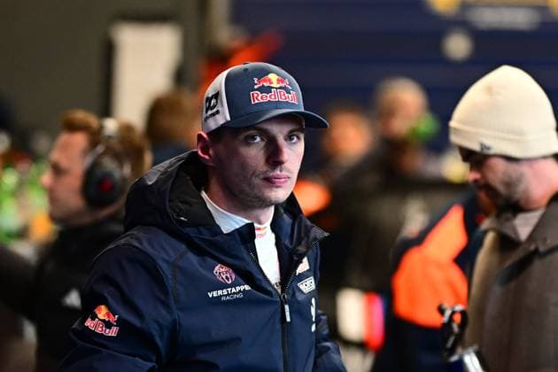 Max Verstappen ist im Fahrerlager des Nürburgrings zu sehen. Er trägt eine dunkelblaue Jacke mit dem Logo von Verstappen Racing sowie eine Red-Bull-Cap. Im Hintergrund sind weitere Personen und das geschäftige Treiben im Paddock zu erkennen. Max Verstappen im Fahrerlager beim 24h Nürburgring 2026 Copyright: xMichaelxGelhardtx