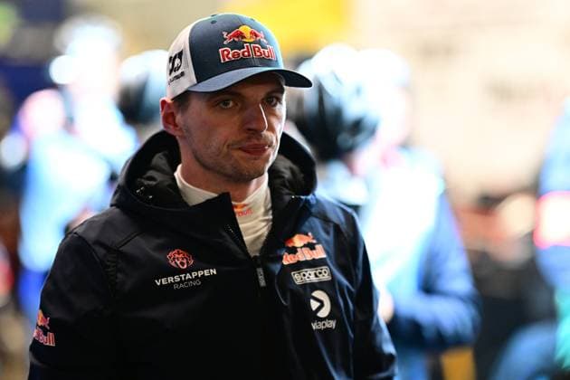 Max Verstappen von Mercedes-AMG Team Verstappen Racing im Fahrerlager des Nürburgrings. Er trägt einen dunkelblauen Teamoverall mit Red Bull- und Viaplay-Sponsoren sowie eine Red-Bull-Cap. Im Hintergrund sind weitere Personen in Teamkleidung zu erkennen. Max Verstappen im Fahrerlager beim 24h Nürburgring 2026 Copyright: xMichaelxGelhardtx