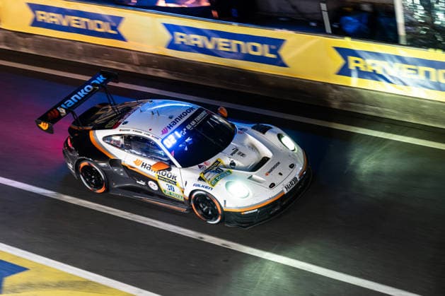 Der Porsche 911 GT3 R (992) Evo26 mit der Startnummer 30 vom Team Hankook Competition mit den Fahrern Jongkyum Kim, Roelof Bruins, Steven Cho und Marco Seefried fährt während des 24h Rennens bei Nacht in der Boxengasse auf der Grand-Prix-Strecke des Nürburgrings. Nürburg Rheinland-Pfalz Deutschland