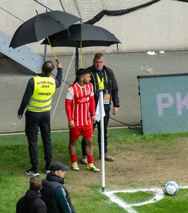 FUSSBALL REGIONALLIGA NORDOST 34. SPIELTAG FC CARL ZEISS JENA - FC ROT WEISS ERFURT ** NUR FÜR REDAKTIONELLE ZWECKE ** EDITORIAL USE ONLY **<p>16 05 2026-Jena: Fussball Regionalliga Nordost 34. Spieltag Saison 2025-2026 Ernst-Abbe-Sportfeld FC Carl Zeiss Jena - FC Rot Weiss Erfurt im Foto: Sejdo Durakov 54 (FC Rot‘Weiß Erfurt) wird beim Eckball von Ordnern mit Schirmen geschützt. ( Deutschland Thueringen Jena Copyright: SaschaxFromm