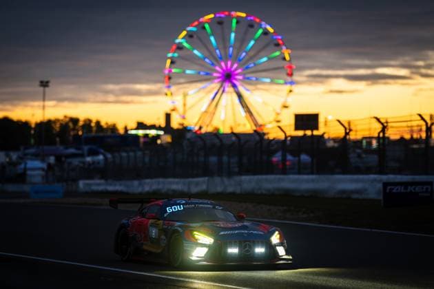 Der Mercedes-AMG GT3 von Red Bull mit der Startnummer 60 durchfährt bei Sonnenuntergang die Strecke am Nürburgring. Im Hintergrund leuchtet ein beleuchtetes Riesenrad in bunten Farben vor einem dramatisch orangefarbenen Abendhimmel. Die eingeschalteten Scheinwerfer des Fahrzeugs unterstreichen die dämmrige Atmosphäre dieses beeindruckenden Motorsport-Moments beim 24h Nürburgring 2026. Mercedes-AMG GT3 60 bei Sonnenuntergang am Nürburgring Copyright: xMichaelxGelhardtx