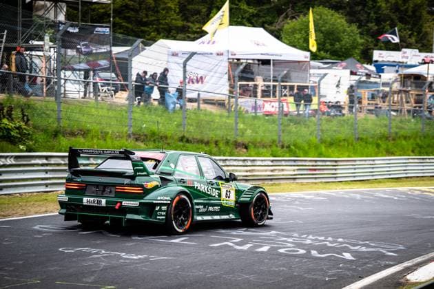 Das markante grüne Fahrzeug mit der Startnummer 63 von HWA Engineering Speed durchfährt eine Kurve auf der Nürburgring-Nordschleife. Der dunkelgrüne Rennwagen trägt auffällige Sponsoren wie Parkside, Hankook, H&R und Composite Impulse und ist mit einem großen Heckflügel ausgestattet. Im Hintergrund sind Zuschauer, Zelte und Werbebanner entlang der Streckenabsperrung zu sehen. Adam Adelson & James Green & Lance David Arnold & Renger Van der Zande (HWA Engineering Speed) HWA 63 Parkside-Fahrzeug auf der Nürburgring-Nordschleife Copyright: xMichaelxGelhardtx