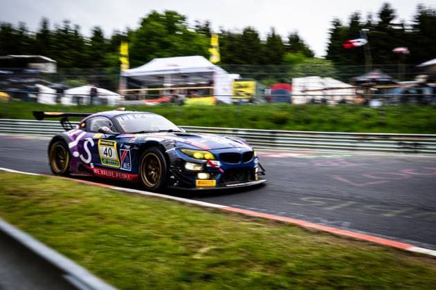 Der BMW Z4 GT3 Frank Nikolaus & Michael Funke & Peter Posavac & Volker Strycek (W.I.S Racing Team powered by Koopman Racing) von W.I.S Racing Team powered by Koopman Racing durchfährt mit hoher Geschwindigkeit eine Kurve auf dem Nürburgring. Das Fahrzeug in charakteristischer blau-lila Lackierung trägt die Sponsoren RAVENOL, DEKRA und das Motto WE.VALUE.PEOPLE . Die goldenen Felgen und gelben Scheinwerfer sind deutlich erkennbar, während der Hintergrund durch den Panning-Effekt verwischt ist. BMW Z4 GT3 40 von W.I.S Racing Team auf dem Nürburgring Copyright: xMichaelxGelhardtx