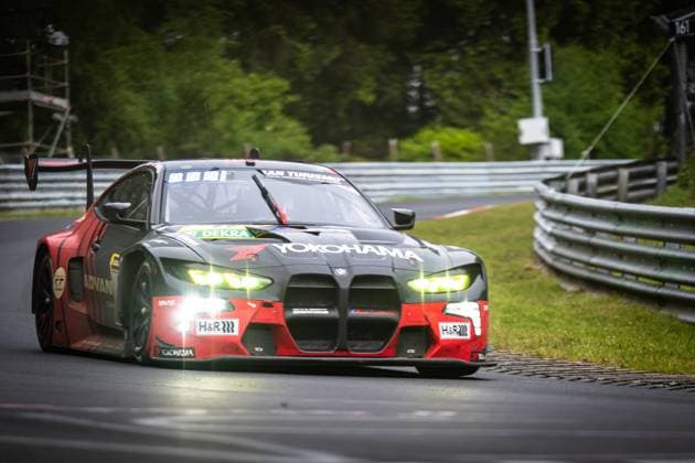 Der BMW M4 GT3 Jens Klingmann & Ugo de Wilde (Schubert Motorsport) von Schubert Motorsport nimmt eine Kurve auf der Nordschleife des Nürburgrings. Das Fahrzeug trägt eine markante schwarz-rote Lackierung mit prominenten Yokohama- und ADVAN-Sponsoren sowie H&R-Federtechnik. Die Scheinwerfer leuchten hell, während der Wagen mit aktivem Heckflügel über den Asphalt gleitet. BMW M4 GT3 81 von Schubert Motorsport auf der Nordschleife Copyright: xMichaelxGelhardtx