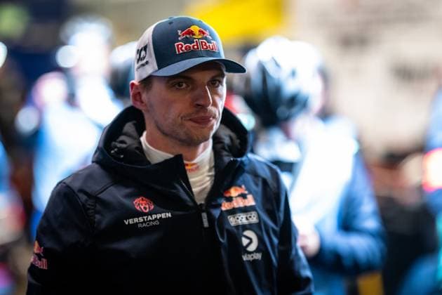 Max Verstappen ist im Fahrerlager des Nürburgrings zu sehen. Er trägt die dunkelblaue Teamjacke von Mercedes-AMG Team Verstappen Racing mit Red Bull- und Viaplay-Sponsoring sowie eine Red-Bull-Cap. Im Hintergrund sind weitere Personen in Teamkleidung erkennbar. Max Verstappen im Fahrerlager beim 24h Nürburgring 2026 Copyright: xMichaelxGelhardtx