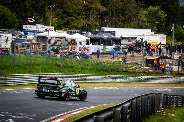 Das Adam Adelson & James Green & Lance David Arnold & Renger Van der Zande (HWA Engineering Speed) von HWA Engineering Speed durchfährt eine Kurve auf der Nordschleife am Nürburgring. Das dunkelgrüne Fahrzeug trägt die Startnummer 63 und ist mit den Sponsoren PARKSIDE, H&R, RONAL und CTIEK beschriftet. Im Hintergrund verfolgen zahlreiche Zuschauer das Rennen von der Böschung aus, während Werbebanner von ROWE Motor Oil und Grünbeck zu sehen sind. Grüner Rennwagen 63 von HWA Engineering Speed auf der Nordschleife Copyright: xMichaelxGelhardtx