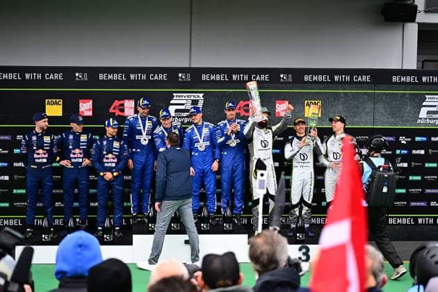 Die Fahrer von Mercedes-AMG Team RAVENOL mit der Startnummer 80 feiern ihren Sieg auf dem Podium der 24h Nürburgring. Das Team hebt den Pokal in die Höhe, während Luca Stolz, Maxime Martin, Fabian Schiller und Maro Engel ihre Erfolgsfahrt krönen. Daneben steht das Zweitplatzierte Team mit Fahrern in weißem Anzug. Siegerehrung 24h Nürburgring: Mercedes-AMG Team RAVENOL triumphiert Copyright: xMichaelxGelhardtx