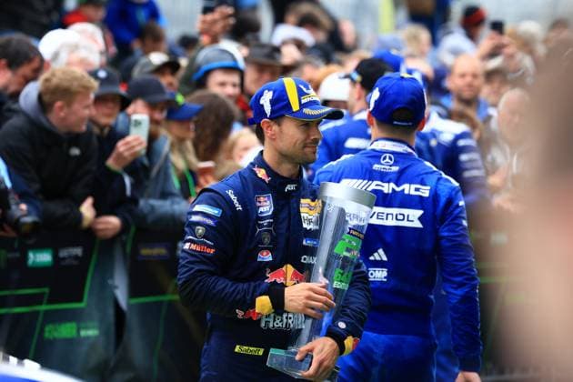 Fahrer von Mercedes-AMG Team RAVENOL mit dem Siegerpokal im Fahrerlager nach erfolgreichem 24-Stunden-Rennen auf dem Nürburgring. Das Team präsentiert stolz die Trophäe nach dem Langstrecken-Klassiker. Mercedes-AMG Team RAVENOL feiert Sieg beim 24h Nürburgring
