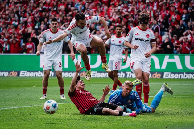2. Bundesliga: Hannover 96 vs. 1. FC Nürnberg, 17.05.2026 Berkay Yilmaz (1. FC Nürnberg, 21) springt über Daisuke Yokota (Hannover 96, 18) und Jan Reichert (1. FC Nürnberg, 1) liegt am Boden; Fußball, 2. Bundesliga, 34. Spieltag: Hannover 96 vs. 1. FC Nürnberg am 17.05.2026 in der Heinz von Heiden Arena, Hannover DFL REGULATIONS PROHIBIT ANY USE OF PHOTOGRAPHS AS IMAGE SEQUENCES AND OR QUASI-VIDEO.
