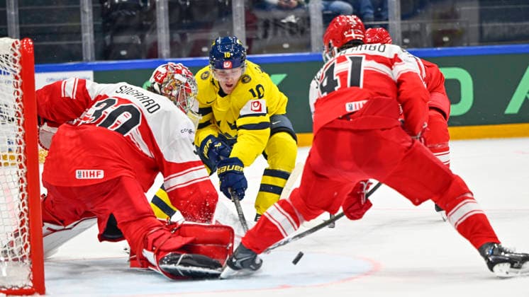 FRIBOURG, SCHWEIZ 20260517 Sveriges Simon Holmström mot Danmarks malvakt Mads Sogaard och Jesper Jensen Aabo under söndagens match i ishockey-VM mellan Danmark och Sverige pa BCF Arena, Fribourg i Schweiz.