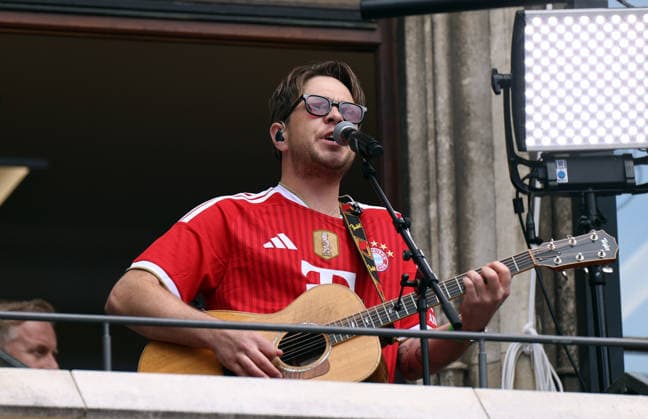 Fussball, Herren, Bundesliga, Saison 2025 2026, FC Bayern München, Meisterfeier, Rathausbalkon, Marienplatz Da Oimara, Benedikt Hafner, mit Gitarre auf dem Rathausbalkon spielend und singend
