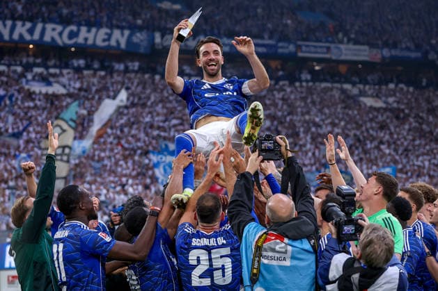 17.05.2026, Fußball, FC Schalke 04 - Eintracht Braunschweig, 34. Spieltag, 2. Fußball Bundesliga, Veltins-Arena Gelsenkirchen, Saison 2025 2026: Schalke 04 ist Meister der 2. Bundesliga. Die Mannschaft gewinnt die Meisterschaft und steht jubelnd auf dem Spielfeld. Freude und Emotionen nach dem Sieg. Die Mannschaft lässt Kenan Karaman (Schalke04 19) mit der Trophy Player of the Season hochleben. Karaman wird in die Luft geworfen mit okal Auszeichnung Spieler der Saison in der Hand DFB regulations prohibit any use of photographs as image sequences and or quasi-video. Nordrhein-Westfalen Deutschland