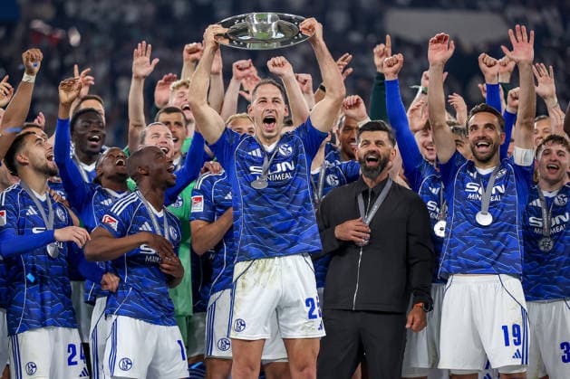 17.05.2026, Fußball, FC Schalke 04 - Eintracht Braunschweig, 34. Spieltag, 2. Fußball Bundesliga, Veltins-Arena Gelsenkirchen, Saison 2025 2026: Schalke 04 ist Meister der 2. Bundesliga. Die Mannschaft gewinnt die Meisterschaft und steht jubelnd auf dem Spielfeld. Freude und Emotionen nach dem Sieg. Übergabe Siegerehrung Nikola Katic (Schalke04 25) mit der Meisterschale in der Hand neben Cheftrainer Miron Muslic (Schalke04) auf dem Podest DFB regulations prohibit any use of photographs as image sequences and or quasi-video. Nordrhein-Westfalen Deutschland