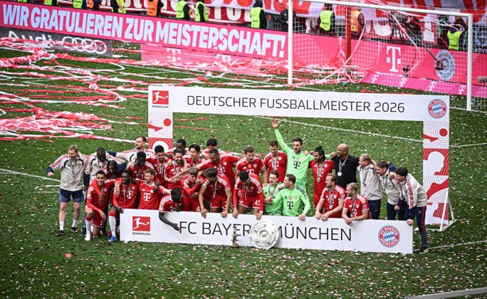 Fussball 1. Bundesliga Saison 2025 2026 34. Spieltag FC Bayern Muenchen - 1. FC Koeln 16.05.2026 Das Team des FC Bayern feiert den Gewinn der 35. Deutschen Meisterschaft, Teambild, der Sponsor Telekom gratuliert auf der Werbebande. Torwarttrainer Michael Rechner, Co Trainer Floribert N Galula, Michael Olise, Co Trainer Rene Maric, Bara Sapoko Ndiaye, Luis Diaz, Raphael Guerreiro, Nicolas Jackson, Hiroki Ito, Min-Jae Kim, Jonathan Tah, Leon Goretzka, Josip Stanisic, Torwart Sven Ulreich, Serge Gnabry, Trainer Vincent Kompany, Co Trainer Aaron Danks, Co Trainer Walter Gfrerer, Co Trainer Daniel Fradley (hinten v.li.) Jamal Musiala, Alphonso Davies, Joshua Kimmich, Dayot Upamecano, Lennart Karl, Tom Bischof, Aleksandar Pavlovic, Torwart Jonas Urbig, Torwart Manuel Neuer, Harry Kane und Konrad Laimer (vorn v.li.,) mit Meisterschale