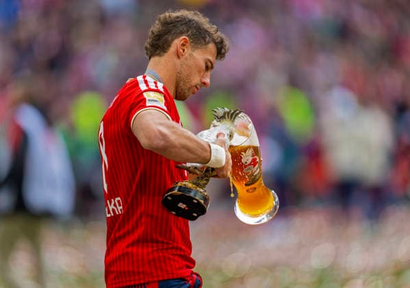16.05.2026, Fussball Bundesliga 2025 2026, 34.Spieltag, FC Bayern München - 1.FC Köln, in der Allianz-Arena München, Nach dem Spiel die Siegerehrung für den Deutschen Meister Bayern München, Leon Goretzka (FC Bayern München) lässt seinen Lieblingsvogel, der weisse Kakadu aus Porzellan, das Kult-Maskottchen der Bayern auch mal aus seinem Weissbierglas trinken. Es ist ja schliesslich auch das Kakadu-Glas mit dem Vogel aufgedruckt.