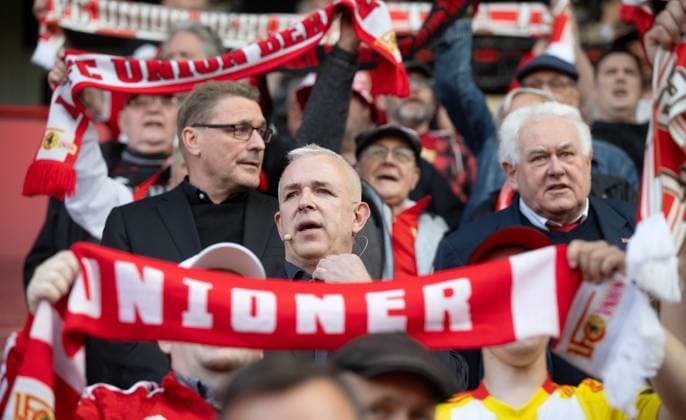 Fußball, Herren, Saison 2025 2026, 1. Bundesliga, 1. FC Union Berlin, Ordentliche Mitgliederversammlung im Stadion An der Alten Försterei, v. l. Finanz-Geschäftsführer Oskar Kosche (1. FC Union), Präsident Dirk Zingler (1. FC Union), Ehrenratsvorsitzender Wolfgang Vallentin (1. FC Union) bei der Hymne, 19.05. 2026, Copyright: xMatthiasxKochx