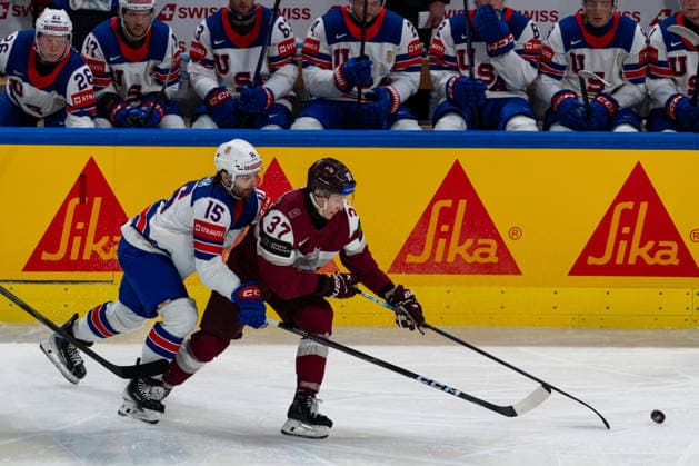 ZURICH, SWITZERLAND - MAY 23: Tommy Novak (United States, 15) in the battle for the puck with Oskars Lapinskis (Latvia, 37) during the Preliminary Round - Group A Match 37 between Latvia and United States at the IIHF Ice hockey, Eishockey World Championship, WM, Weltmeisterschaft 2026, Swiss Life Arena on May 23, 2026 in Zurich, Switzerland. Zurich Switzerland Copyright: xTimoxSteinx