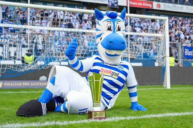 23.05.2026, xydrx, Herren, Fußball, Finaltag der Amateure, Finale Niederrheinpokal, SC St. Tönis 11 ‹20 - MSV Duisburg, Saison 2025 2026, Schauinsland-Reisen-Arena: Das Maskottchen des MSV Duisburg posiert mit dem Pokal Copyright: HMBxMedia YannisxDreimann