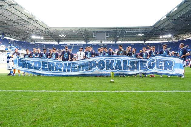 23.05.2026, xydrx, Herren, Fußball, Finaltag der Amateure, Finale Niederrheinpokal, SC St. Tönis 11 ‹20 - MSV Duisburg, Saison 2025 2026, Schauinsland-Reisen-Arena: die Spieler des MSV Duisburg bejubeln den Sieg im Finale mit einem Banner in der Hand Copyright: HMBxMedia YannisxDreimann