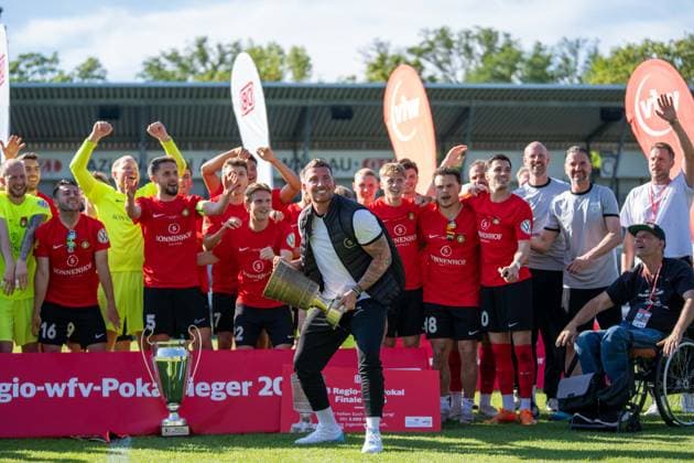 Pascal Reinhardt (Trainer SG Sonnenhof Großaspach) streckt den Pokal in die hoehe, im Hintergrund jubelt seine Mannschaft, Stuttgarter Kickers vs. SG Sonnenhof Großaspach, Fussball, WFV-Pokal, Finale, 23.05.2026 Stuttgart-Degerloch Baden-Wuerttemberg Deutschland