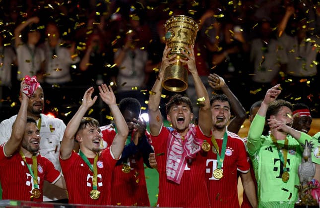 Fussball DFB Pokal Finale 2025 2026 in Berlin FC Bayern Muenchen - VfB Stuttgart 23.05.2026 Sieger FC Bayern Muenchen jubelt auf dem Podium: v. li., Raphael Guerreiro, Lennart Karl, Tom Bischof , Aleksandar Pavlovic