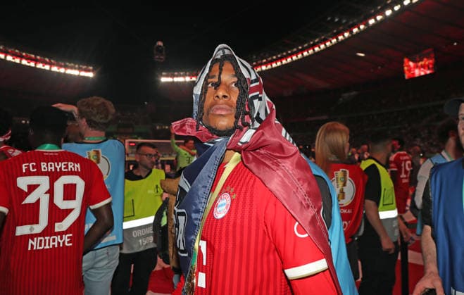 Fussball, Herren, DFB-Pokal Finale, Saison 2025 2026, FC Bayern München - VFB Stuttgart, Olympiastadion Berlin Die Mannschaft des FC Bayern München feiert den Gewinn des DFB-Pokal hier nach dem Spiel, im Bild Michael Olise (FC Bayern München) mit einer Fahne über dem Kopf, Tuch DFB, DFL regulations prohibit any use of photographs as image sequences and or quasi-video