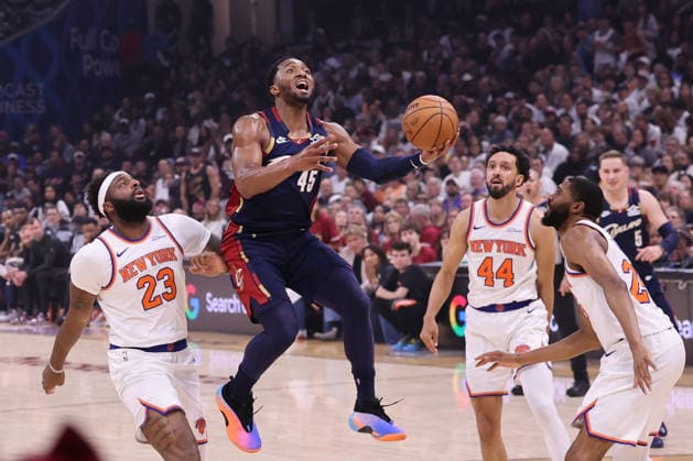 Cleveland Cavaliers Donovan Mitchell (45) adjusts his shot while defended by New York Knicks Mitchell Robinson (23) and Mikal Bridges (25) during the third quarter of their Eastern Conference Final game in Cleveland, Ohio Saturday May 23, 2026.  CLE20260523121 AARONxJOSEFCZYK