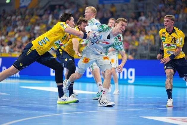 Ein SC-Magdeburg-Spieler im weißen Trikot kämpft intensiv um den Ball, während Edwin Aspenbäck ( 78, Rhein-Neckar Löwen) und Steven Plucnar Jacobsen ( 9, Rhein-Neckar Löwen) in gelben Trikots Druck ausüben. Die Szene zeigt einen hart umkämpften Angriff in der DAIKIN HBL in der SAP Arena. Edwin Aspenbäck und Steven Plucnar Jacobsen (Rhein-Neckar Löwen) im Zweikampf gegen SC Magdeburg