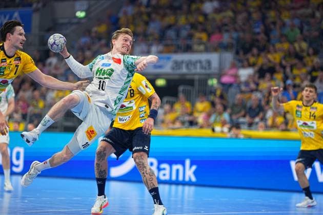 Gisli Thorgeir Kristjansson ( 10, SC Magdeburg) zieht im weißen SCM-Trikot aus dem Sprung ab, während Robert Timmermeister ( 7, Rhein Neckar Löwen) links im Bild zu sehen ist. Die vollbesetzte SAP Arena bildet den Rahmen dieses Duells in der DAIKIN HBL. Gisli Thorgeir Kristjansson ( 10, SC Magdeburg) mit Sprungwurf in der SAP Arena