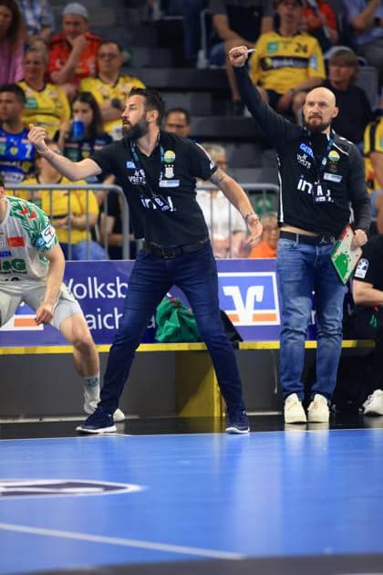 SC Magdeburg-Trainer Bennet Wiegert gestikuliert leidenschaftlich an der Seitenlinie während des DAIKIN HBL-Spiels gegen die Rhein Neckar Löwen in der SAP Arena. Neben ihm steht ein weiterer Betreuer des Trainerstabs mit Taktikboard. Bennet Wiegert (SC Magdeburg) feuert sein Team in der SAP Arena an