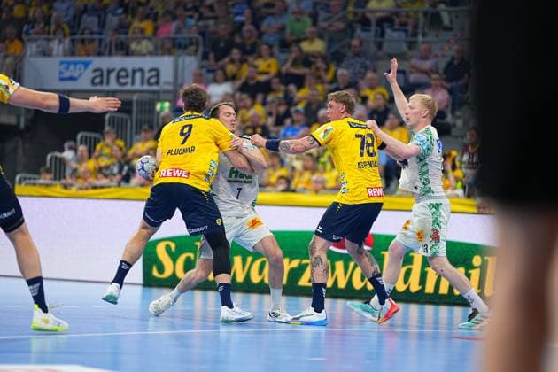 Felix Claar ( 7, SC Magdeburg) wird in der SAP Arena von Steven Plucnar Jacobsen ( 9) und Edwin Aspenbäck ( 78) der Rhein Neckar Löwen in die Zange genommen. Der SC-Magdeburg-Spieler versucht sich im Zweikampf zu behaupten. Felix Claar ( 7, SC Magdeburg) unter Druck gegen Rhein Neckar Löwen in der SAP Arena
