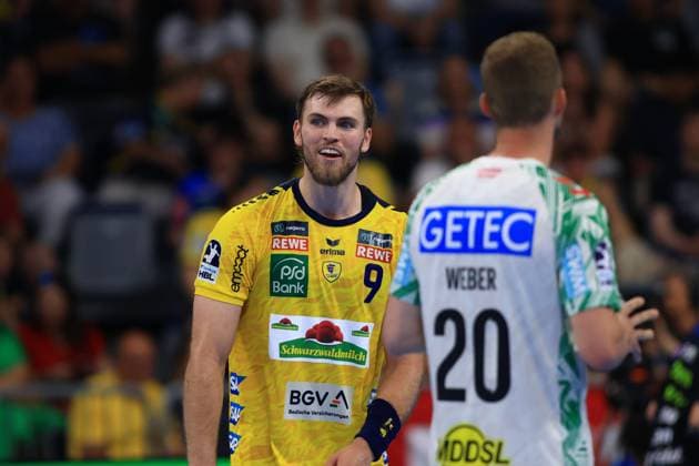 Steven Plucnar Jacobsen ( 9, Rhein Neckar Löwen) steht lächelnd Philipp Weber ( 20, SC Magdeburg) gegenüber in der SAP Arena. Beide Spieler stehen dicht beieinander während einer Spielpause. Steven Plucnar Jacobsen ( 9; Rhein Neckar Löwen) im Duell mit Philipp Weber