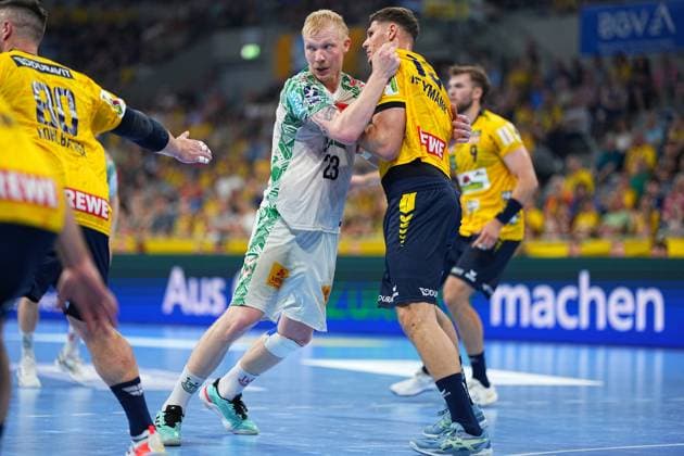 Magnus Saugstrup ( 23, SC Magdeburg) kämpft im weißen Trikot gegen Sebastian Heymann ( 13, Rhein Neckar Löwen) um die Position in der SAP Arena. Links im Bild ist Jannik Kohlbacher ( 80, Rhein Neckar Löwen) zu sehen. Magnus Saugstrup ( 23; SC Magdeburg) im Zweikampf gegen Sebastian Heymann