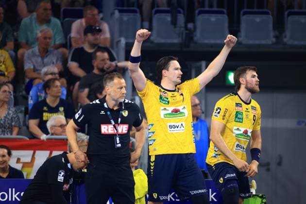Robert Timmermeister ( 7, Rhein Neckar Löwen) reißt beide Arme jubelnd in die Höhe an der Seitenlinie der SAP Arena. Trainer Maik Machulla steht neben ihm, während Steven Plucnar Jacobsen ( 9) rechts daneben die Situation verfolgt. Robert Timmermeister jubelt mit Maik Machulla und Steven Plucnar Jacobsen (Rhein Neckar Löwen) in der SAP Arena