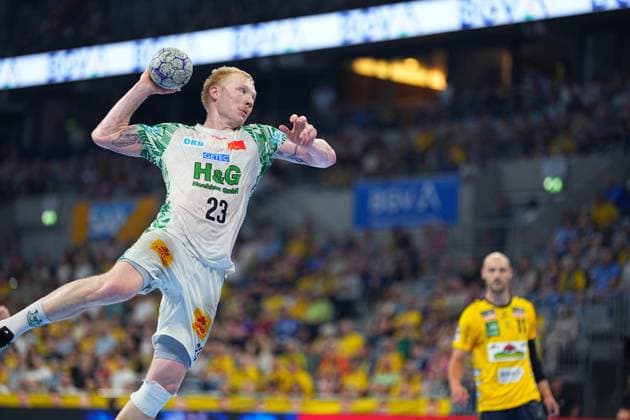 Magnus Saugstrup ( 23; SC Magdeburg) springt ab und wirft den Ball in der SAP Arena beim Spiel gegen die Rhein Neckar Löwen. Im Hintergrund ist ein Spieler der Rhein Neckar Löwen mit der Nummer 11 zu sehen. Magnus Saugstrup ( 23; SC Magdeburg) beim Sprungwurf in der SAP Arena