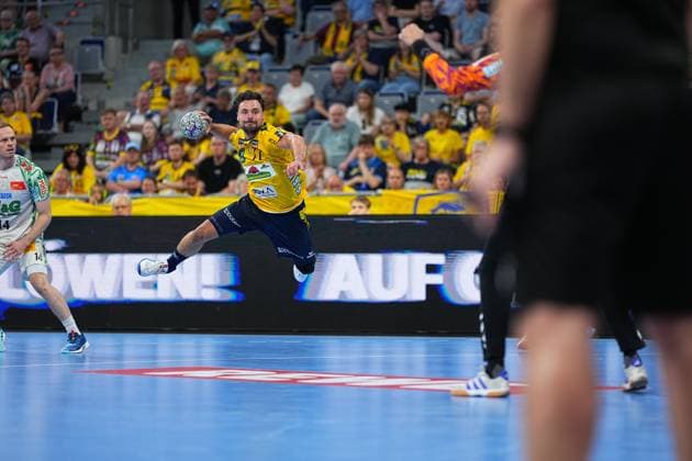 Dani Baijens ( 77; Rhein Neckar Löwen) springt ab und zieht einen Wurf auf das Tor, während Omar Ingi Magnusson ( 14; SC Magdeburg) im Hintergrund als Abwehrspieler positioniert ist. Im Bildhintergrund verfolgen zahlreiche Zuschauer das Spiel in der gut besetzten SAP Arena. Dani Baijens ( 77; Rhein Neckar Löwen) beim Sprungwurf in der SAP Arena