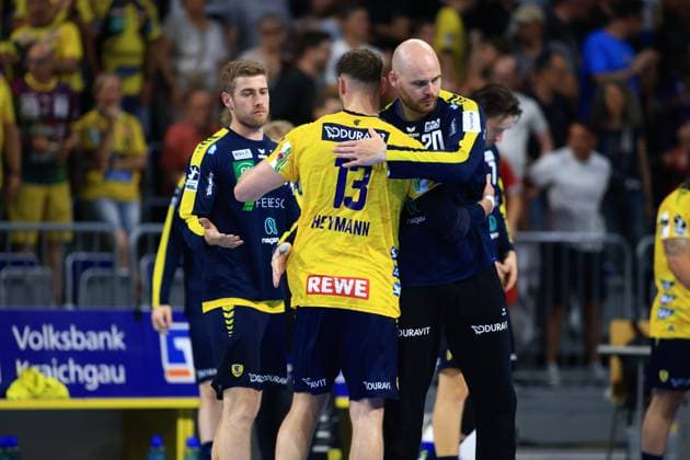 Torwart Mike Jensen ( 20; Rhein Neckar Löwen) umarmt Sebastian Heymann ( 13) nach dem Spiel in der SAP Arena, während Tim Nothdurft im Hintergrund steht. Alle drei tragen die gelb-blauen Farben der Rhein Neckar Löwen. Mike Jensen ( 20; Rhein Neckar Löwen) umarmt Sebastian Heymann ( 13) in der SAP Arena