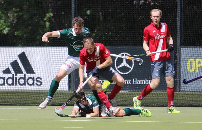 Feldhockey-Bundesliga der Herren: Alster-Spieler Jack Heldens im Kampf um den Ball mit Lukas Mertgens und Max Godau (am Boden).
